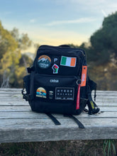 Nomad 25L Carbon Black backpack with patches outdoors
